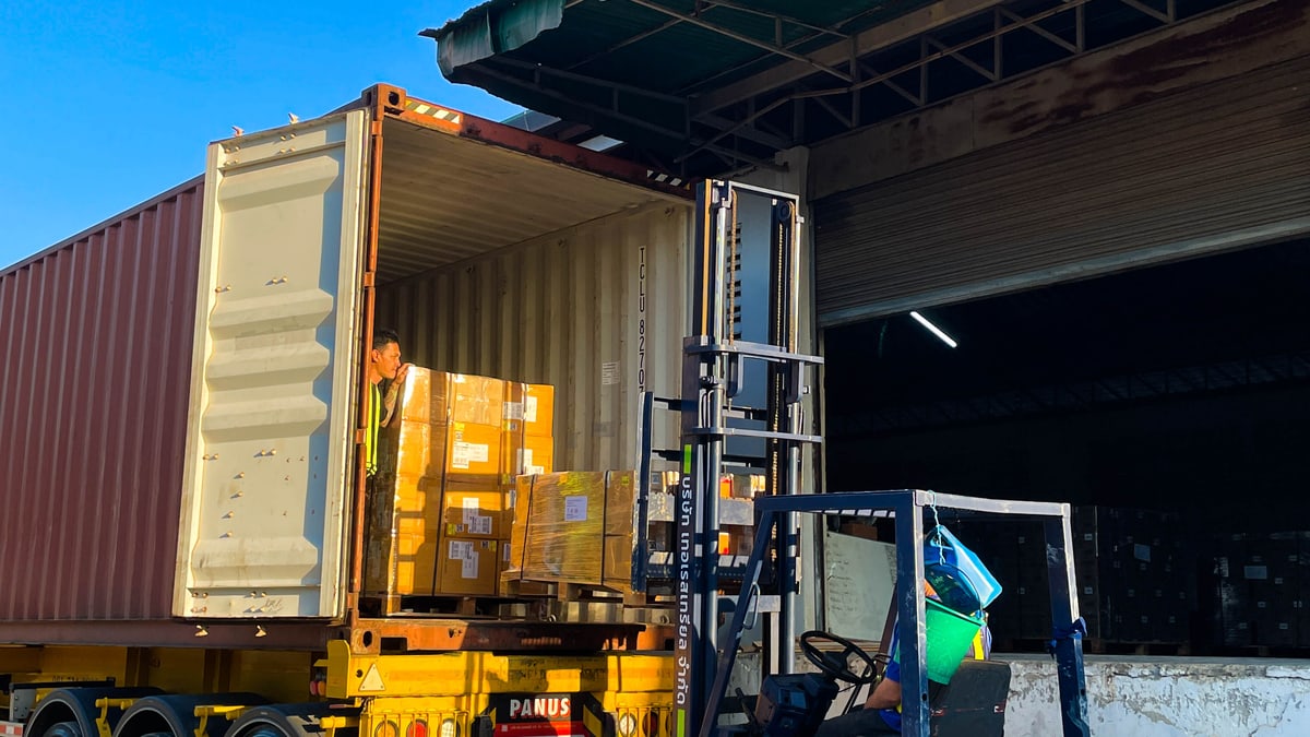 Forklift loading palletized cargo into a shipping container