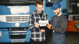 Freight documentation review beside an international cargo vehicle